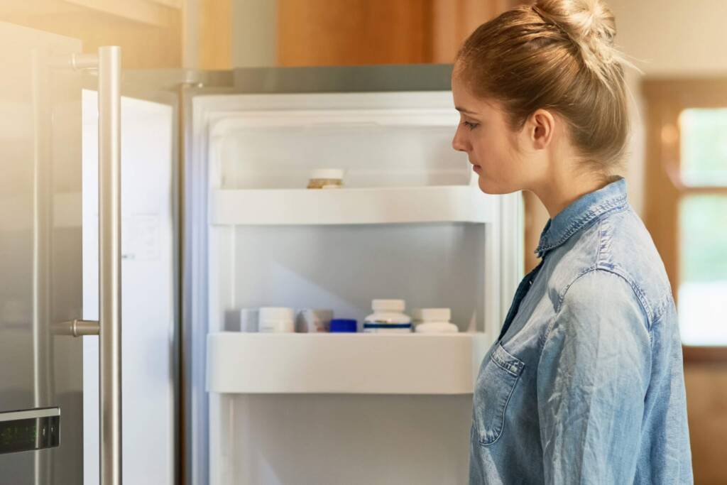 Frau vor Kühlschrank